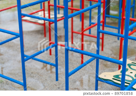 Outdoor playsets and benches wet in the rain 89701858
