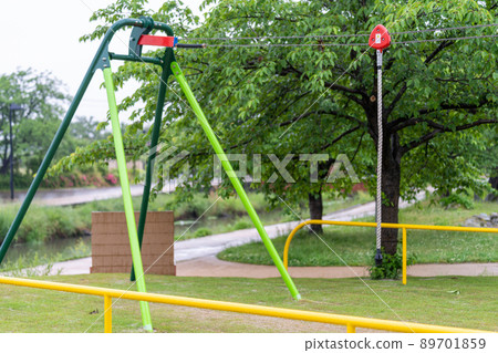 Outdoor playsets and benches wet in the rain 89701859