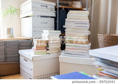 Room with stacked books and boxes Moving and decluttering Room with stacked books and boxes Moving and decluttering 89702041