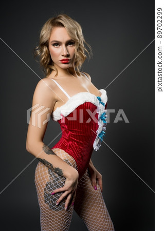 Slim seductive woman portrait in red Snow Maiden costume 89702299