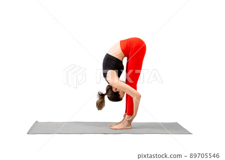 Slim caucasian woman practicing yoga, standing forward fold pose, Uttanasana, isolated on white. 89705546