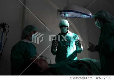 Medical team performing surgery. Group of surgeons in hospital operation theater. Doctor team medical their success Medical team performing surgery. Group of surgeons in hospital operation theater. Doctor team medical their success 89707420