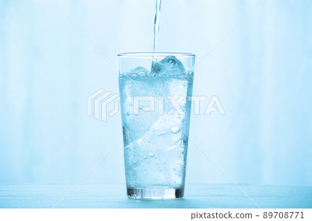 Carbonated water poured into a glass of ice 89708771