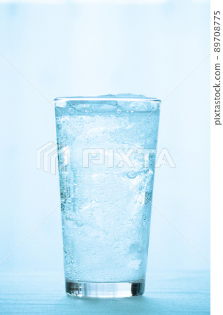 Carbonated water poured into a glass of ice 89708775