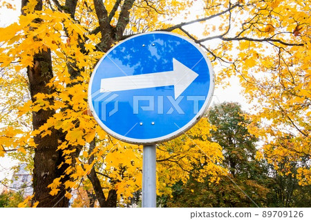 Blue road sign with white arrow pointing right 89709126