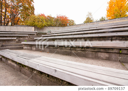 Row of wooden benches at summer theater in a city park 89709137