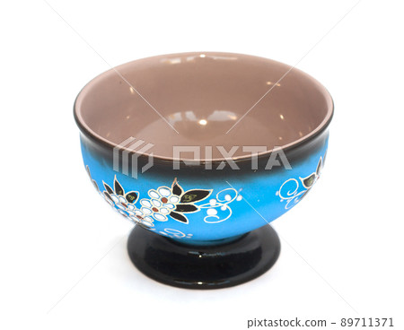 Blue cup with flower decoration on white background Blue cup with flower decoration on white background 89711371