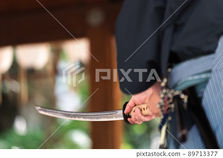 A person holding a Japanese sword 89713377