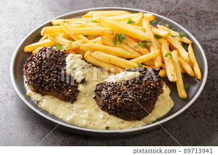 Steak au Poivre with Cognac Cream Sauce and french fries close-up in a plate. Horizontal Steak au Poivre with Cognac Cream Sauce and french fries close-up in a plate. Horizontal 89713941