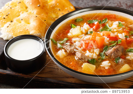 Asian soup with lamb, rice and vegetables close-up in a bowl. horizontal 89713953