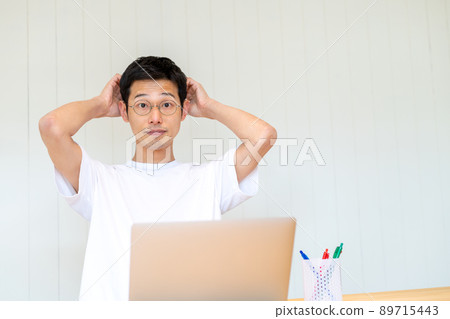 一個沉迷於電腦工作，抱著頭和眼睛的人是一個重點 89715443