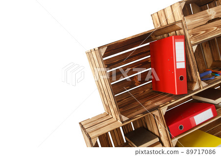 Folders with documents, books and stationery in a rack of wooden boxes isolated on white background. 89717086