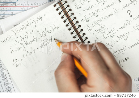 Math formulas are written in pencil in a notebook holding man in Math formulas are written in pencil in a notebook holding man in 89717240