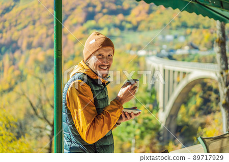 Montenegro. Man touriste in background of Dzhurdzhevich Bridge Over The River Tara foggy morning. Travel around Montenegro concept. Sights of Montenegro 89717929