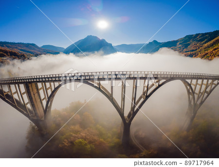 Montenegro. Dzhurdzhevich Bridge Over The River Tara foggy morning Montenegro. Dzhurdzhevich Bridge Over The River Tara foggy morning 89717964