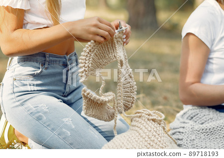 Girl in a park. Woman knitting outside. Lady working. 89718193