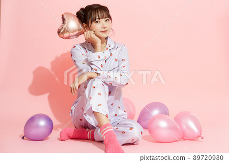 粉紅色背景中一位穿著睡衣的年輕女子的肖像 89720980