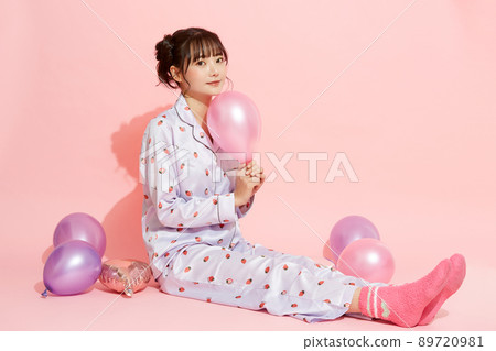 粉紅色背景中一位穿著睡衣的年輕女子的肖像 89720981