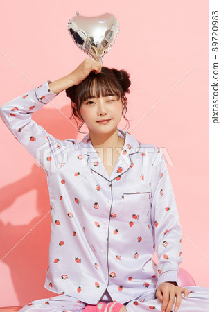 粉紅色背景中一位穿著睡衣的年輕女子的肖像 89720983