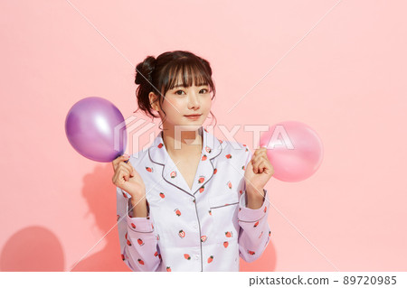 粉紅色背景中一位穿著睡衣的年輕女子的肖像 89720985