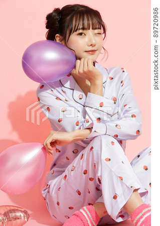 粉紅色背景中一位穿著睡衣的年輕女子的肖像 89720986