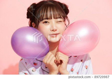 粉紅色背景中一位穿著睡衣的年輕女子的肖像 89720987