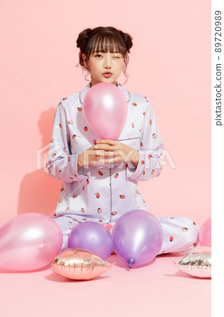 粉紅色背景中一位穿著睡衣的年輕女子的肖像 89720989