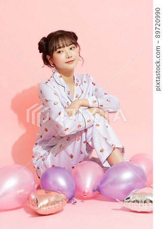 粉紅色背景中一位穿著睡衣的年輕女子的肖像 89720990