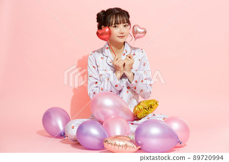 粉紅色背景中一位穿著睡衣的年輕女子的肖像 89720994