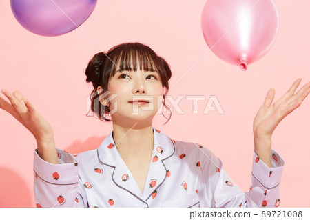 粉紅色背景中一位穿著睡衣的年輕女子的肖像 89721008