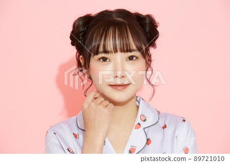 粉紅色背景中一位穿著睡衣的年輕女子的肖像 89721010