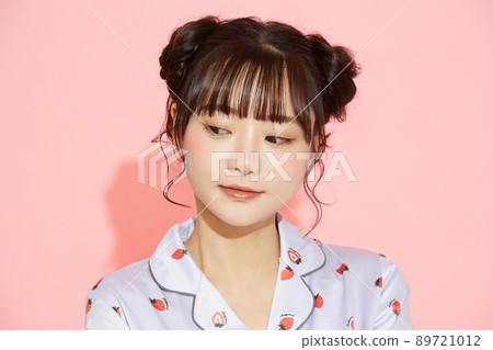 粉紅色背景中一位穿著睡衣的年輕女子的肖像 89721012