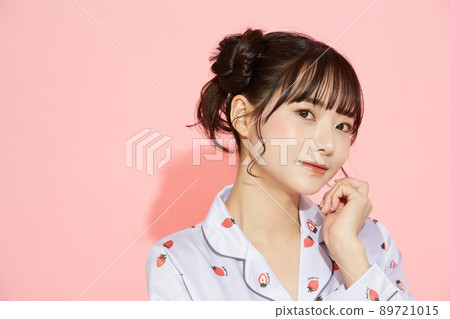 粉紅色背景中一位穿著睡衣的年輕女子的肖像 89721015