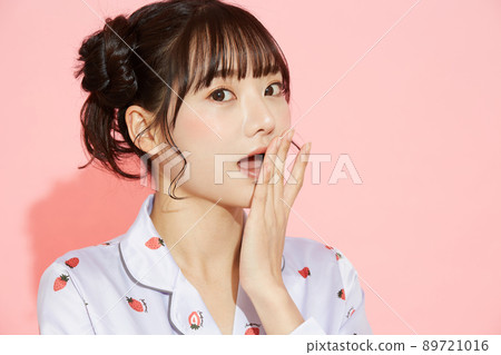 粉紅色背景中一位穿著睡衣的年輕女子的肖像 89721016