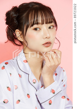 粉紅色背景中一位穿著睡衣的年輕女子的肖像 89721022