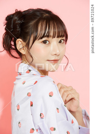 粉紅色背景中一位穿著睡衣的年輕女子的肖像 89721024