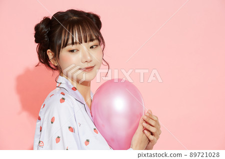 粉紅色背景中一位穿著睡衣的年輕女子的肖像 89721028