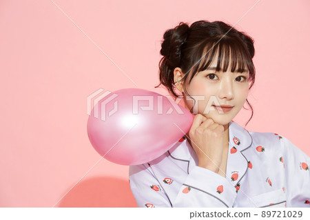 粉紅色背景中一位穿著睡衣的年輕女子的肖像 89721029