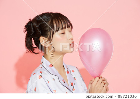 粉紅色背景中一位穿著睡衣的年輕女子的肖像 89721030