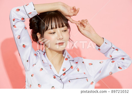 粉紅色背景中一位穿著睡衣的年輕女子的肖像 89721032