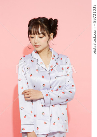 粉紅色背景中一位穿著睡衣的年輕女子的肖像 89721035