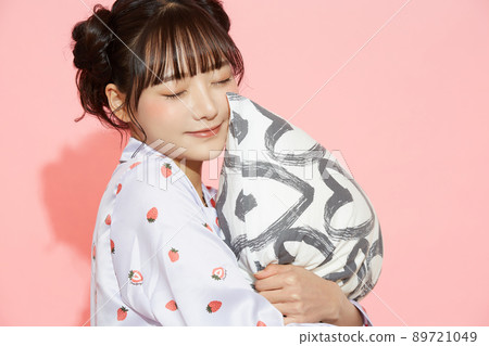 粉紅色背景中一位穿著睡衣的年輕女子的肖像 89721049