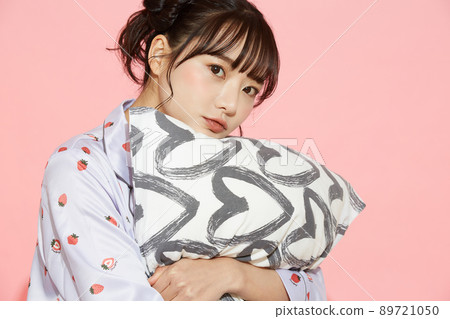 粉紅色背景中一位穿著睡衣的年輕女子的肖像 89721050