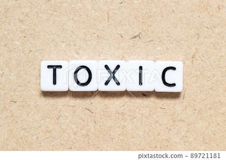 White tile alphabet letter with word toxic on wood background 89721181