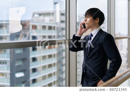 A businessman talking on the phone while looking out 89721345