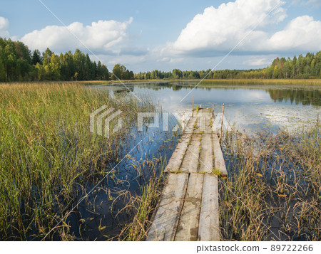 Wooden mooring for boats on Lake Kenozero. Beautiful landscape of clear water and autumn nature. Russia. 89722266