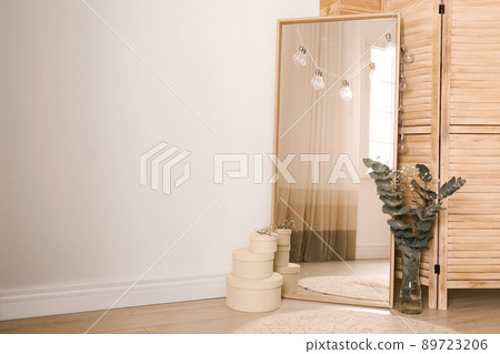 Large mirror near light wall in room. Modern interior design Large mirror near light wall in room. Modern interior design 89723206