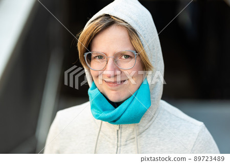 Portrait of a 35 year old woman wearing a hoody, looking confident 89723489