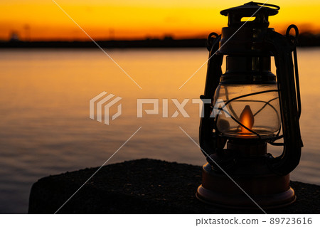 Antique lantern placed near the sea at dusk 89723616