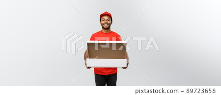 Delivery Concept - Portrait of Handsome African American Pizza delivery man. Isolated on Grey studio Background. Copy Space. 89723658
